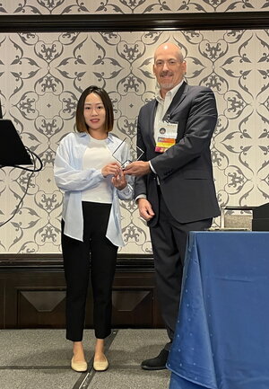 IPAC board director, Michael Blair, presenting the James C. Johnson Student Paper Award to 2023 winner Lingyue Li.