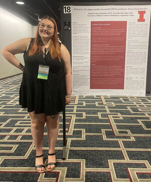 Photograph of Briana Kunstman standing next to a conference poster.